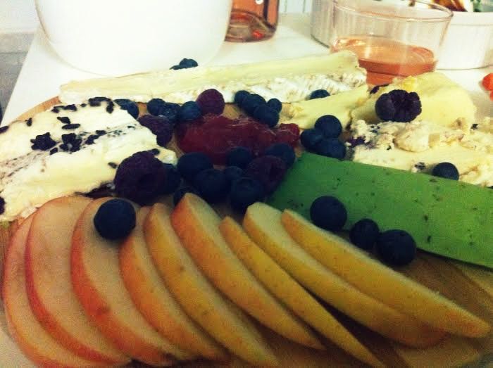 Tabla de quesos con manzana, arándanos, frambuesas y mermelada